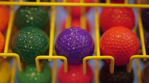Refilling Wire Golf Ball Dispenser with Colorful Minigolf Balls Stock Footage 65971079