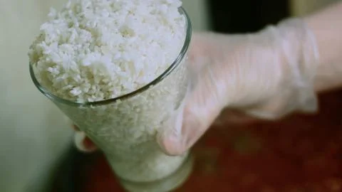 Refined culinary study of pouring white rice into a saucepan Stock Photos