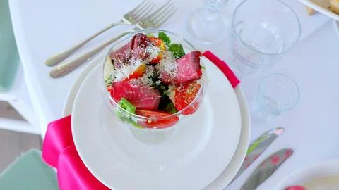 Refined dining setup displaying savory beef salad with tomatoes, arugula Stock Photos