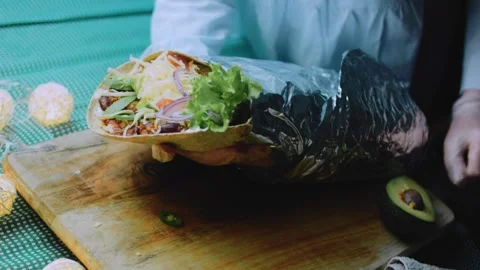 Refined ingredient view: unwrapping a loaded burrito Stock Footage 342168308