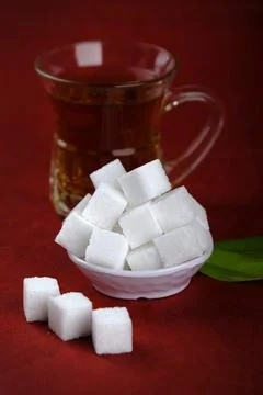 Refined sugar cubes on Red background. Stock Photos