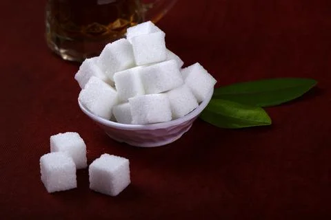 Refined sugar cubes on Red background. Stock Photos