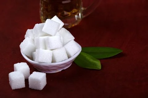 Refined sugar cubes on Red background. Stock Photos