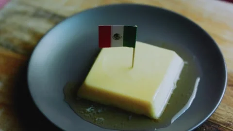 Refined tabletop study of fork cutting into smooth caramel custard Stock Footage 342154153
