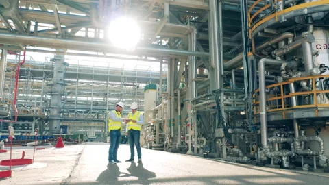 Refinery co-workers are discussing constructions of the factory. Modern Stock Footage 163514541