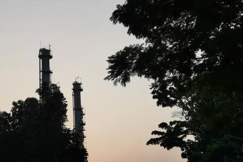 Refinery column on sunset time. Heavy industry oil and gas plant. Pollution a Stock Photos