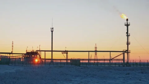 Refinery fire gas torch against a background of sunset in arctic Stock Footage 173256259