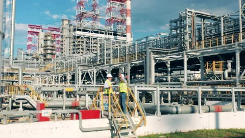 Refinery inspectors are talking next to a massive barrel Stock Footage 163280978