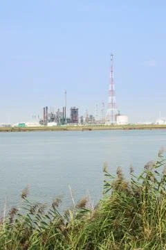 Refinery installations with high torch next to the Scheldt Stock Photos