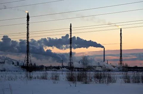 Refinery at sunset sky background. Frosty snowy winter evening Stock Photos