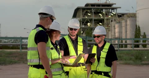 Refinery workforce gathers around laptop and tablet during pipeline inspection Stock Footage 338424959