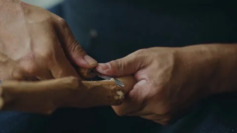 Refining and smoothing a raw wood branch with skilled wood crafting hand Stock Footage 266865233