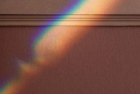 Reflected iridescent rainbow light on the wall in the apartment Stock Photos