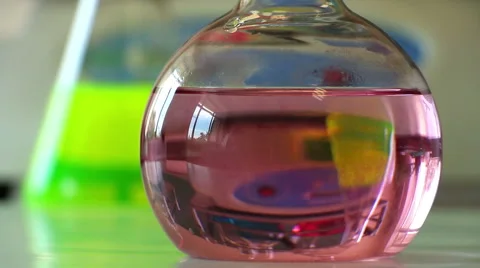 Reflected laboratory shaker motion in the glassware filled with pink liquid Stock Footage 54410129