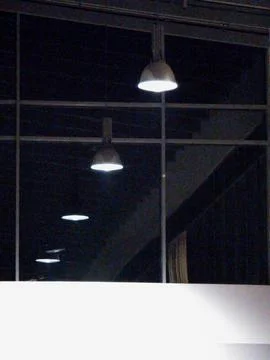 Reflected pendant lights in grid window Stock Photos