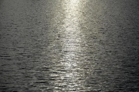 The reflected rays of the setting sun on the water Stock Photos