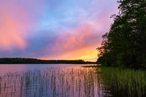 Reflected in the smooth water of the lake clouds at sunset. Colorful landscap Stock Photos