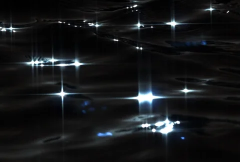 Reflected star patterns on dark water gently rocking in ultra-slow motion Stock Footage 86919984