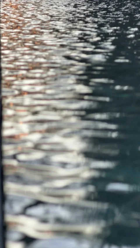 Reflected sunlight flickers across gentle waves on a water surface creating Stock Footage 331247733