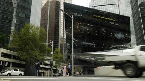 Reflected Sydney traffic on skyscraper and pedestrians below 6K Stock Footage 302778468