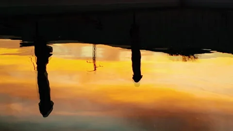 Reflected umbrellas silhouettes in the pool at sunset Stock Footage 133341457