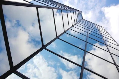 Reflecting clouds in glass facade Stock Photos