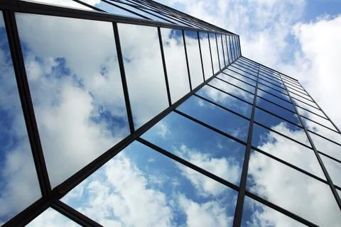 Reflecting clouds in glass facade Stock Photos