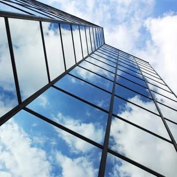 Reflecting clouds in glass facade Stock Photos