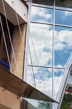 Reflecting clouds in mirrored windows of building Stock Photos