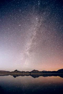 Reflecting pool of mountain range and Milky Way in dramatic night sky, Stock Photos