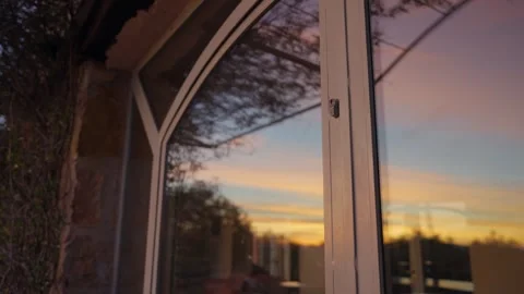 Reflecting sunset sky in an arched window Stock Footage 339098357