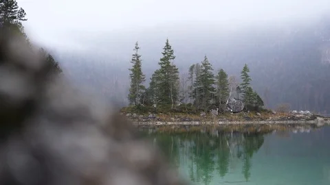 Reflecting trees in lake Eibsee germany at a cloudy day Stock-Footage 120190187