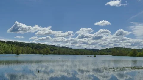 Reflecting white cloud on blue background mirrored in flowing water, UHD 4K Stockbeeldmateriaal 155595184