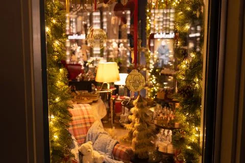 Reflecting window with view from outside into a charming room. Cozy couch wit Stock Photos