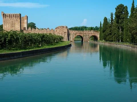 Reflection of an ancient bridge in the water of river Mincio near Verona in I Stock Photos