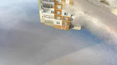 Reflection of an apartment building in a frozen puddle Stock Footage 330405600