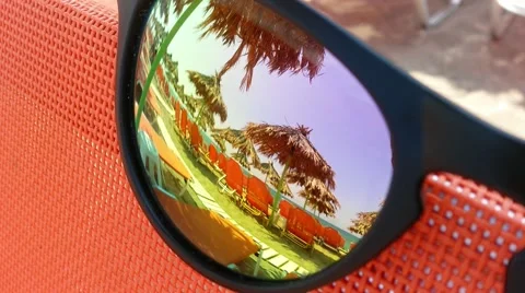 The reflection of a beach umbrella in sunglasses Stock Footage 52129131