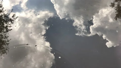 Reflection of beautiful large clouds in puddles on the road after the rain. Stock Footage 131536642