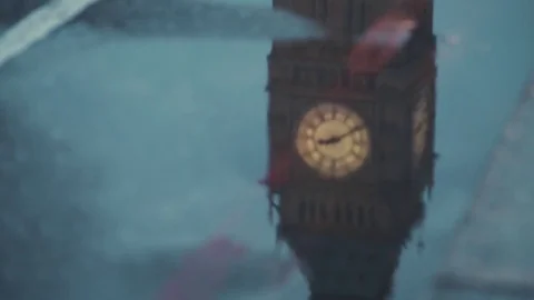 Reflection of Big Ben and double decker buses passing by on puddle in London Stockbeeldmateriaal 80666970