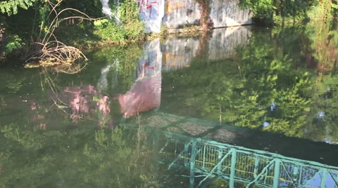 Reflection of a biker that cross the bridge on the water river of a biker Stock-Footage 55667914