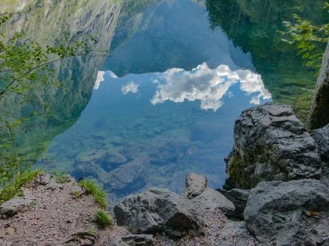 Reflection of a blue cloudy sky and austrian alps Stock Photos