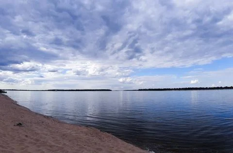 Reflection of the blue sky and clouds in the river. Skyline. Free beach. Stock Photos