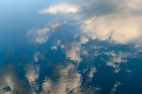 Reflection of the blue sky with white clouds Stock Photos