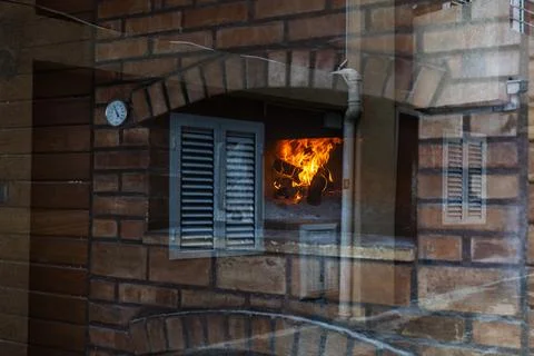 Reflection of brick facade and fire through window glass. Visual overlap of t 写真素材