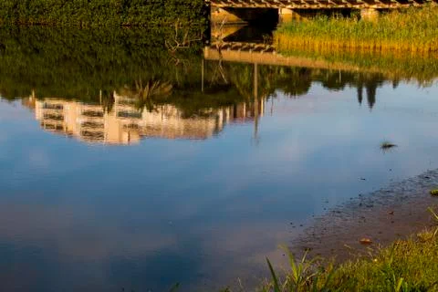 Reflection of Bridge and Building in River Water Stock Photos