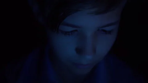 Reflection of a bright multi-colored screen on the boy's face in complete Stock Footage 139263971
