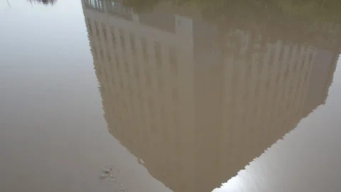 Reflection of building in a mud puddle Stock-Footage 103477300