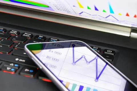 Reflection of  business graph on smartphone Stock Photos