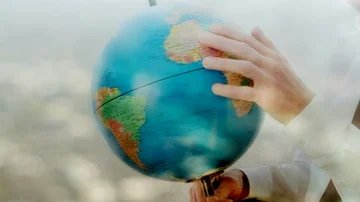 Reflection of a businessman looking at a globe Video stock 85768055