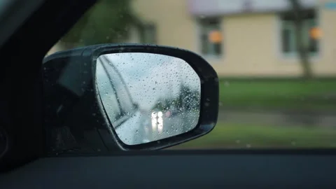 Reflection in car rear mirror while driving in city streets, POV Stock Footage 292456863